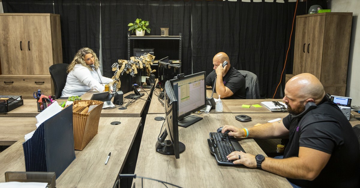 Three Employees working on computers and talking on phones
