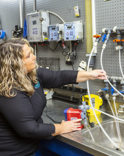 woman standing at a table spinning or coiling tubing